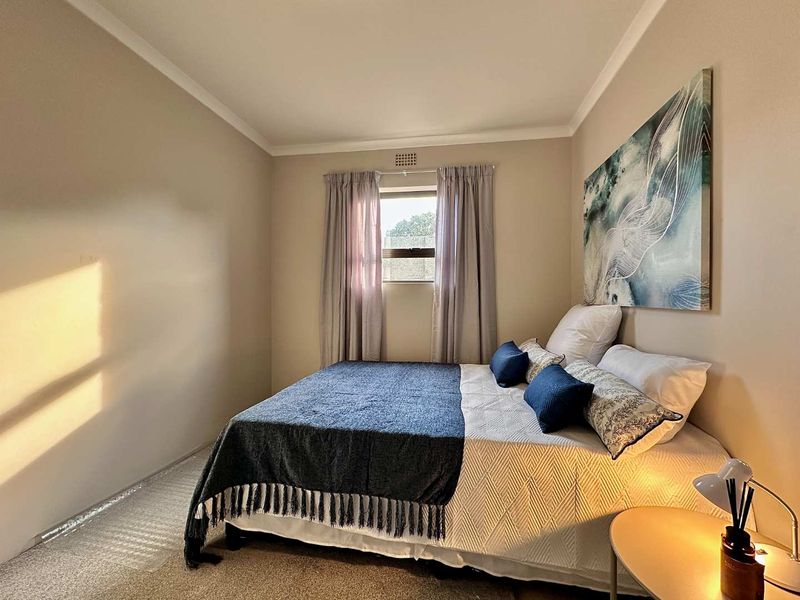 A well-maintained bedroom featuring neutral wall tones, carpeted flooring, and decorative coving, providing a comfortable and inviting living space.