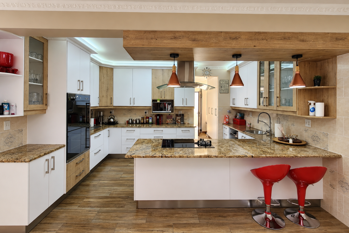 Modern kitchen featuring granite countertops, built-in oven, electric hob, extractor fan, and ample cabinetry with a central island and breakfast bar seating.