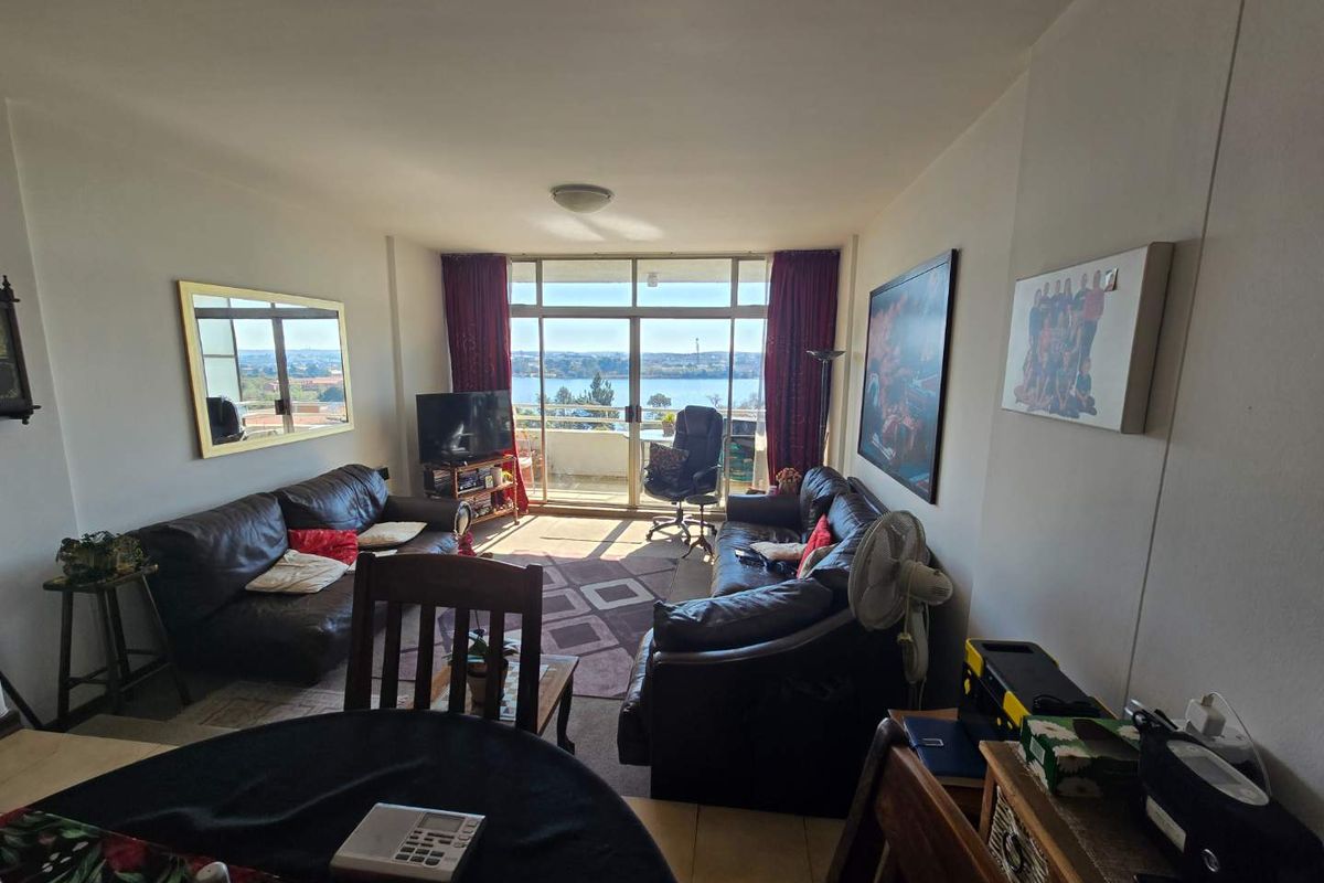A comfortable living room featuring large sliding glass doors that provide natural light and access to a balcony with scenic water views.
