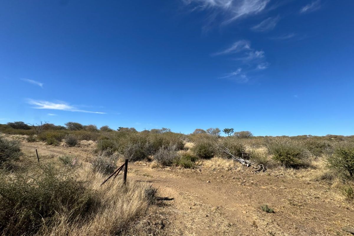 An expansive view of the natural veld landscape on the small holding, featuring dry vegetation and existing wire boundary fencing.