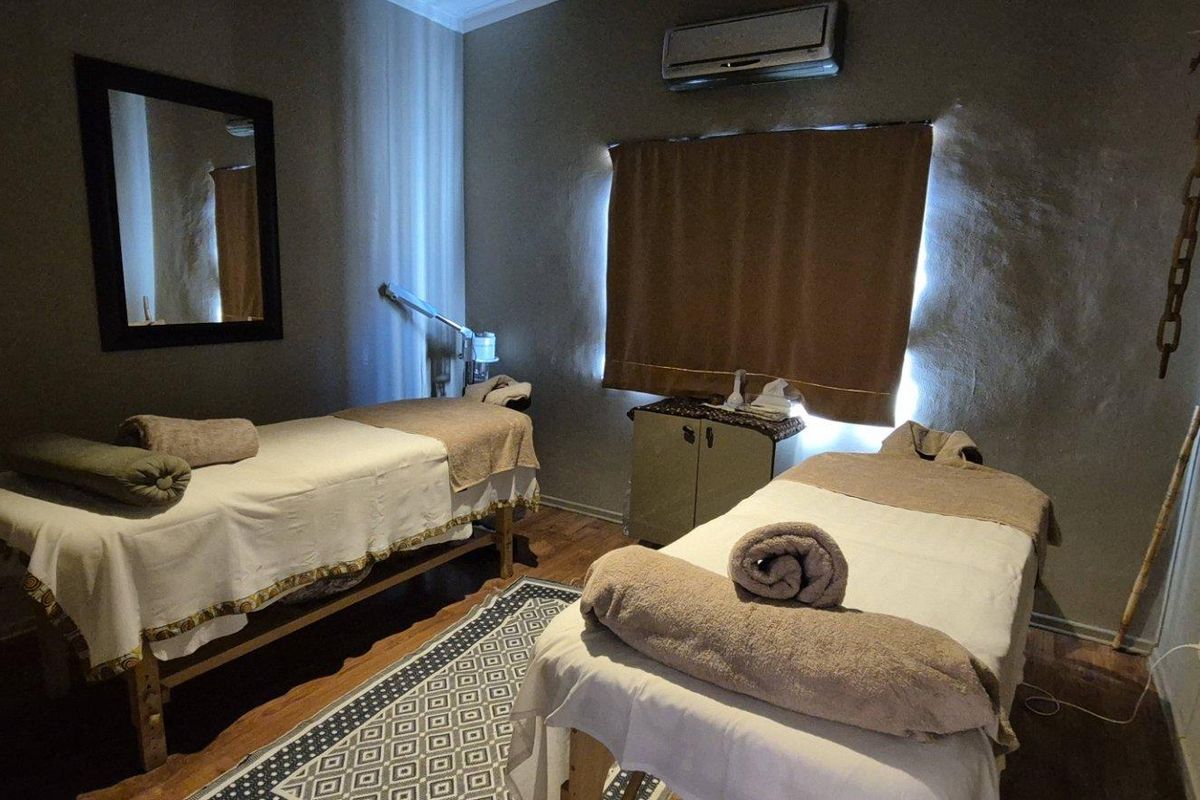 A functional room currently utilized as a treatment space, featuring laminate flooring and a wall-mounted air conditioning unit.