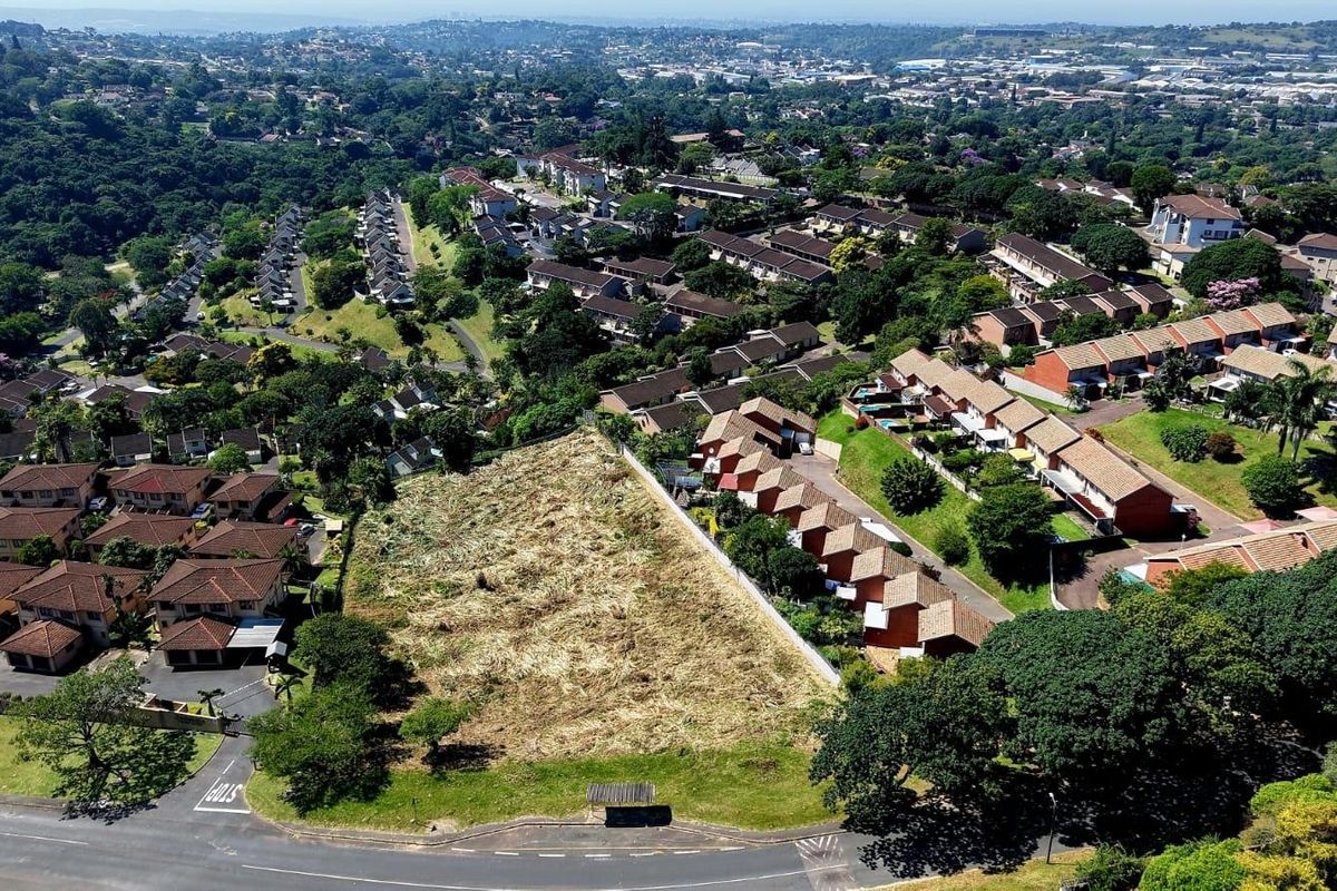 An aerial view of a vacant residential plot situated within an established suburban neighborhood, offering potential for future development.