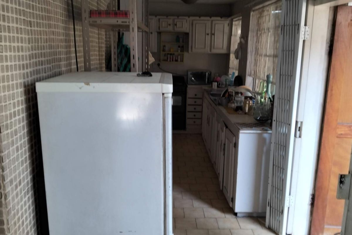 A functional kitchen space featuring built-in cabinetry, tiled flooring, and wall-mounted storage, offering a practical layout for daily meal preparation.