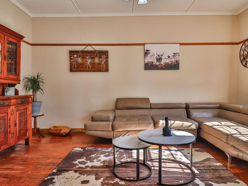 A cozy living room featuring warm hardwood flooring and a classic picture rail, providing a comfortable and inviting space.
