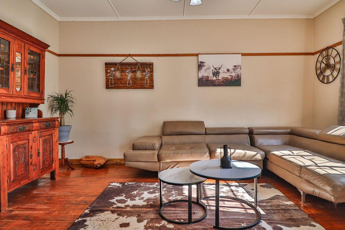 A cozy living room featuring warm hardwood flooring and a classic picture rail, providing a comfortable and inviting space.