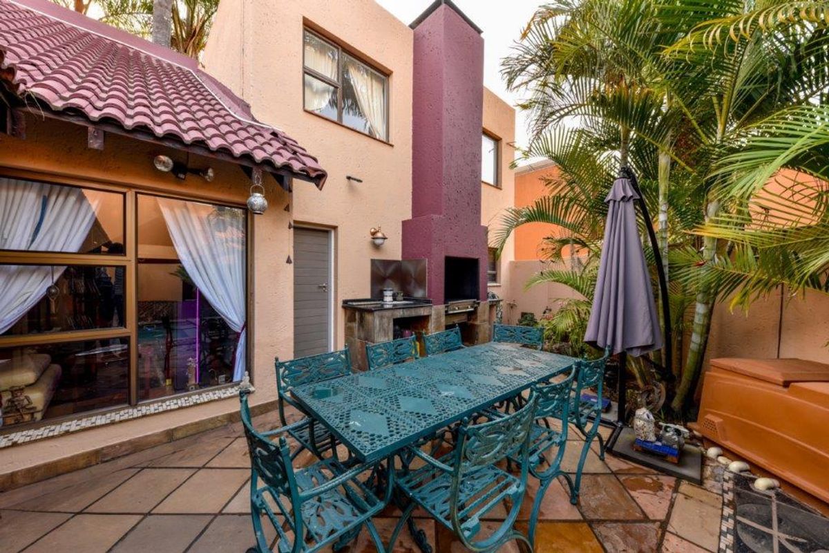 A private rear patio area featuring a built-in brick braai, tiled flooring, and direct access to the interior living space.