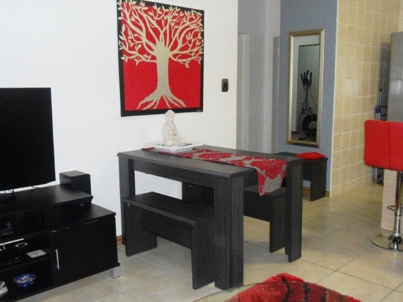 Open plan living and dining area featuring tiled flooring and a tiled kitchen splashback wall.