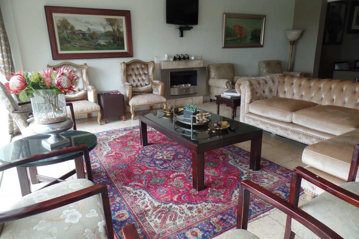 A spacious living room featuring tiled flooring and a built-in fireplace, providing a comfortable and traditional gathering space.