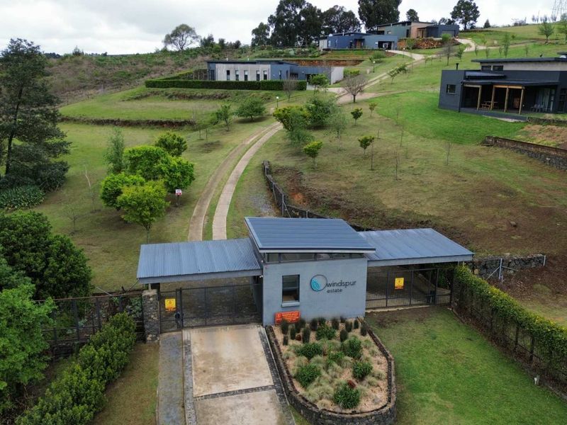 Aerial view of the Windspur Estate entrance, featuring a modern gated access point, paved driveway, and landscaped grounds within a residential estate setting.