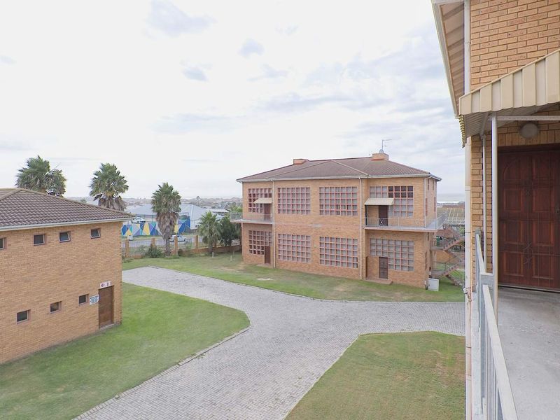 An elevated view of the apartment complex grounds, featuring face brick buildings, paved driveways, and well-maintained lawn areas.