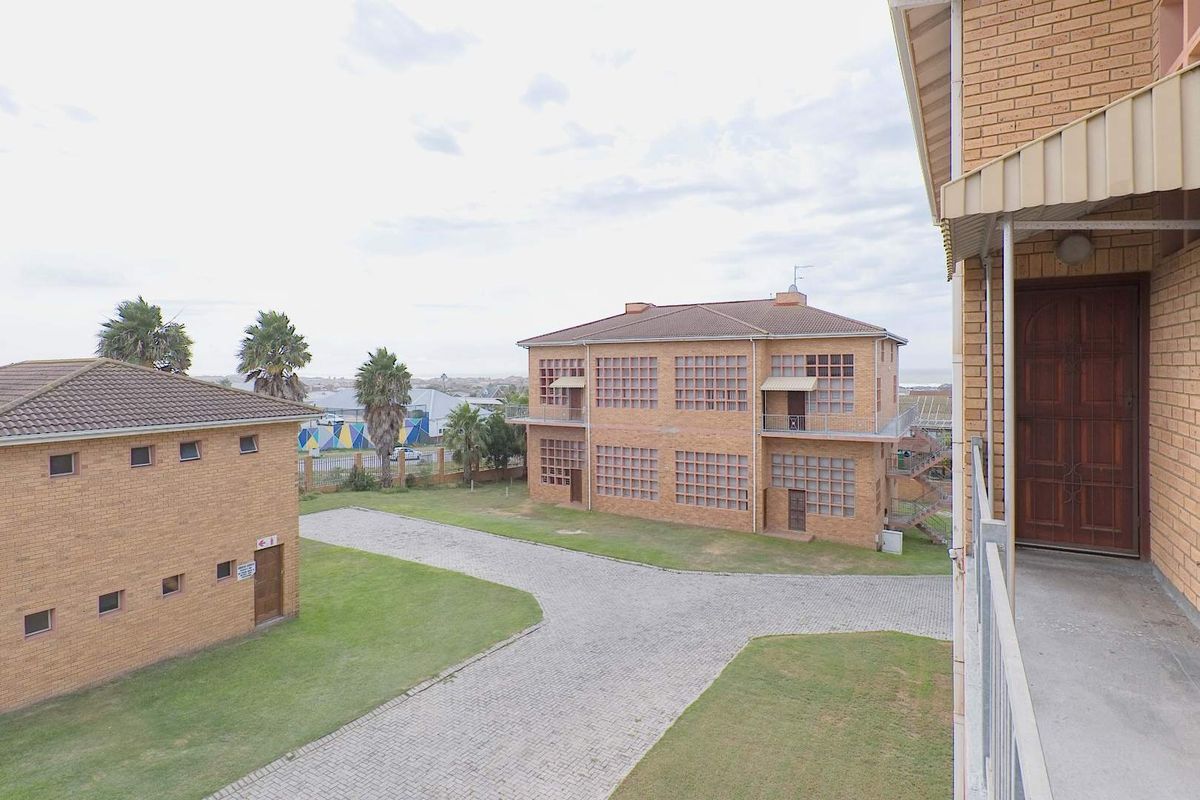 An elevated view of the apartment complex grounds, featuring face brick buildings, paved driveways, and well-maintained lawn areas.