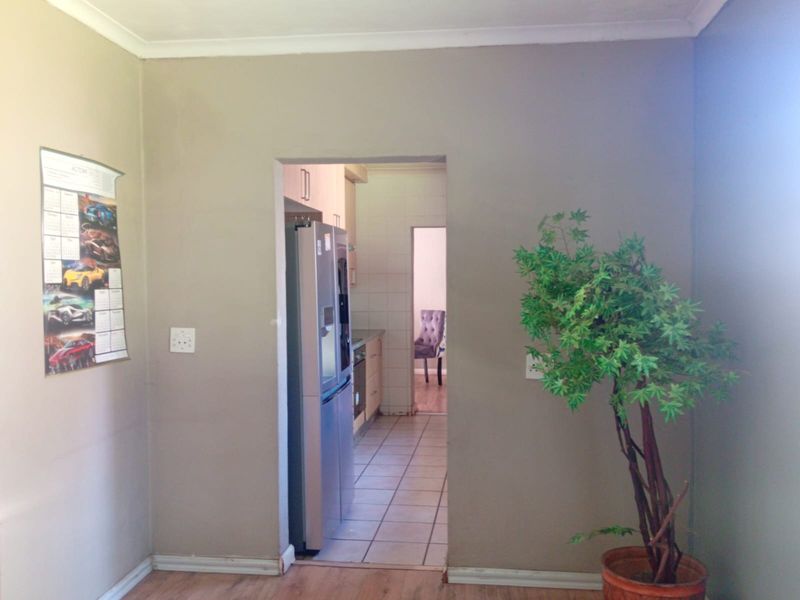 A view through a doorway into a kitchen area featuring tiled flooring and built-in cabinetry.