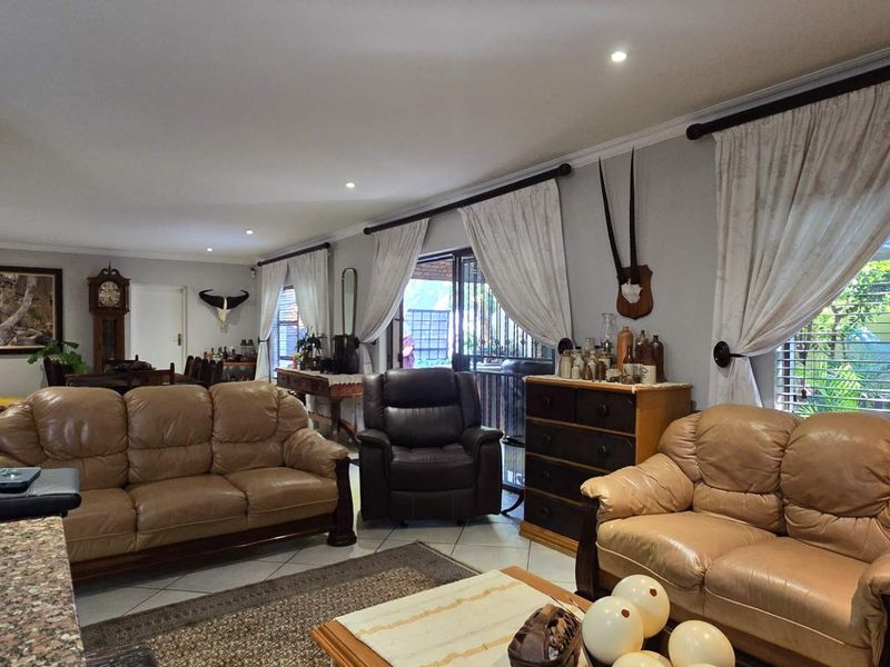 Spacious living area featuring tiled flooring, recessed lighting, and large sliding glass doors that provide access to the outdoor space.