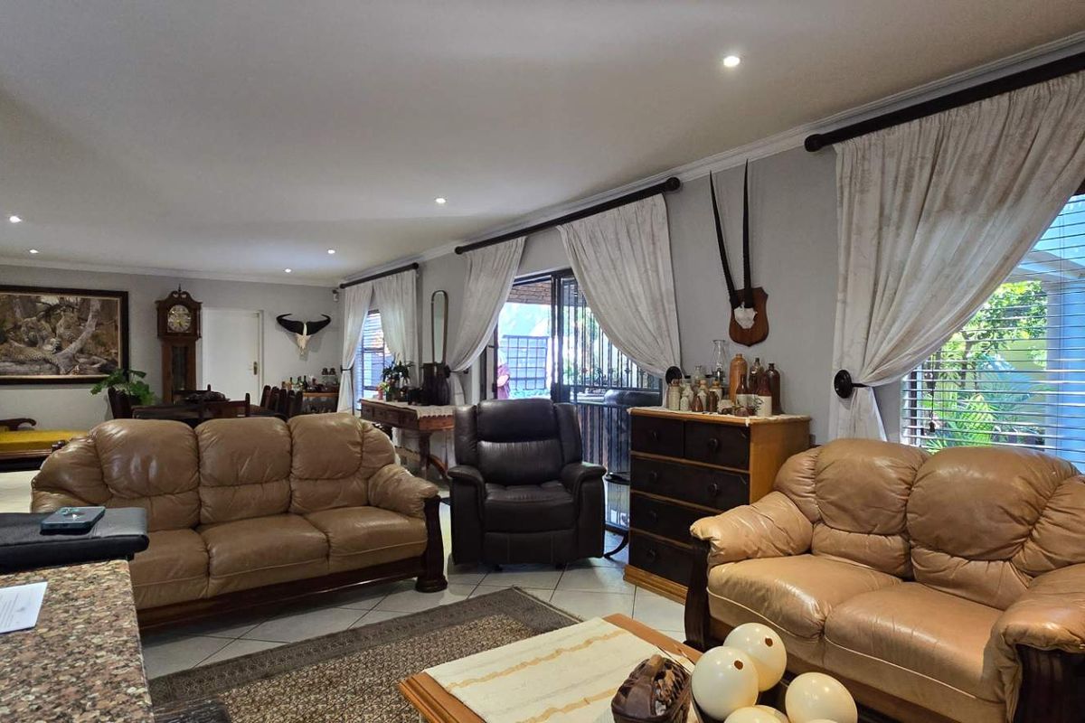 Spacious living area featuring tiled flooring, recessed lighting, and large sliding glass doors that provide access to the outdoor space.