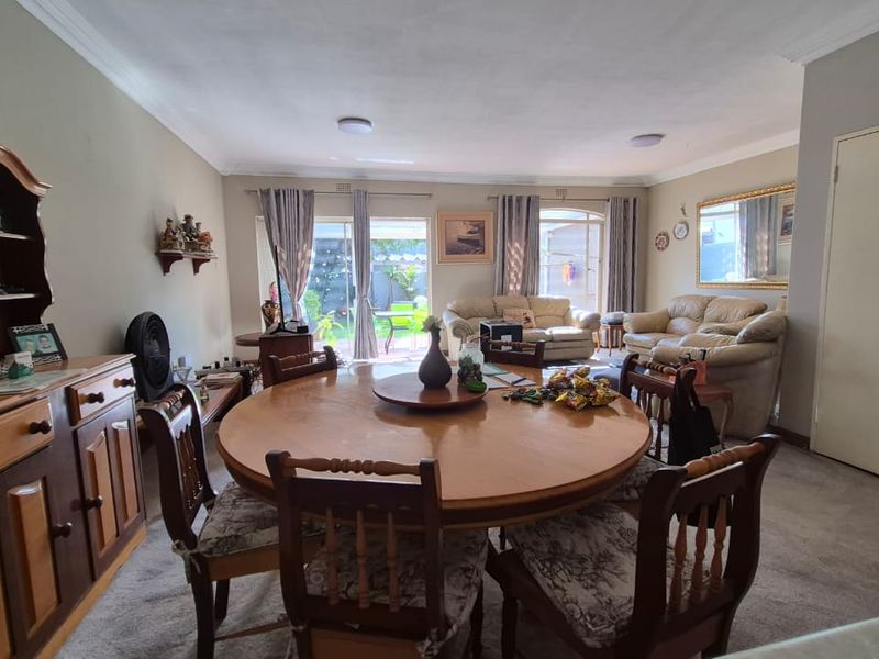 Spacious open-plan living and dining area featuring sliding glass doors that provide natural light and direct access to the rear garden.