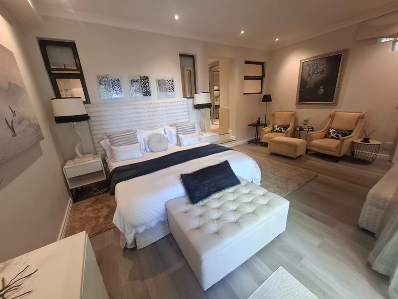 Spacious master bedroom featuring modern laminate flooring, recessed downlighting, and an integrated en-suite bathroom layout.