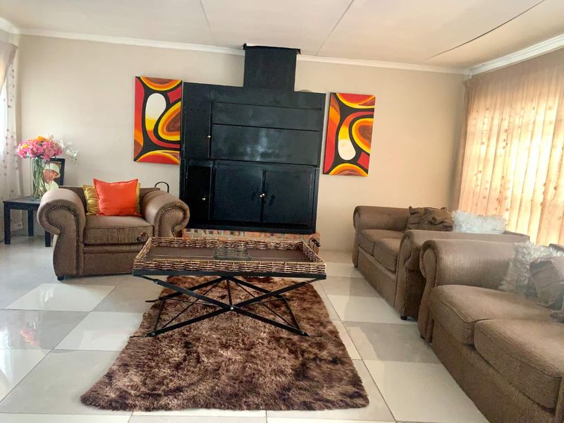 A living room featuring a prominent black built-in fireplace and light-colored tiled flooring.