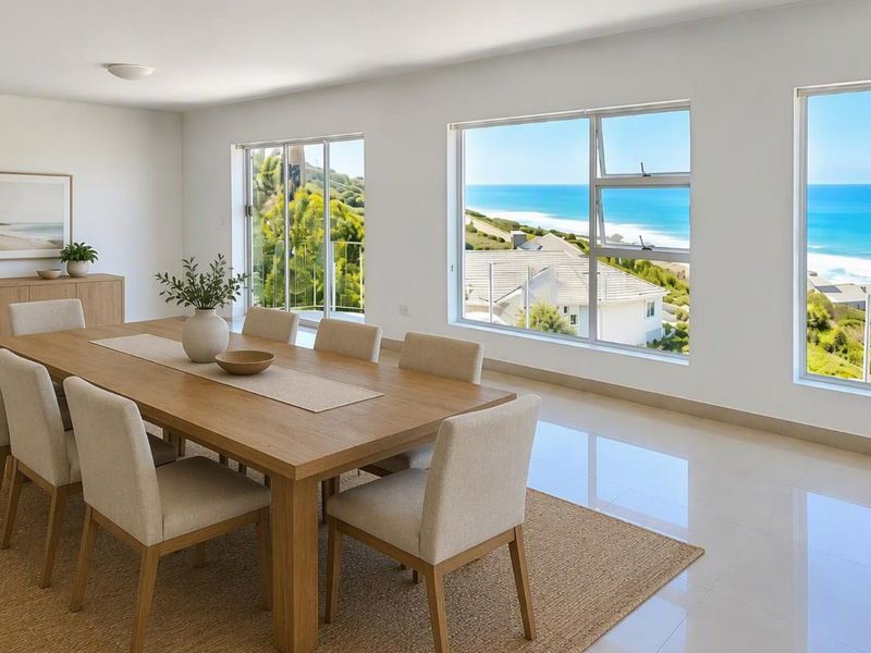 Bright and spacious dining room featuring large format floor tiles and expansive windows offering panoramic ocean and coastal views.