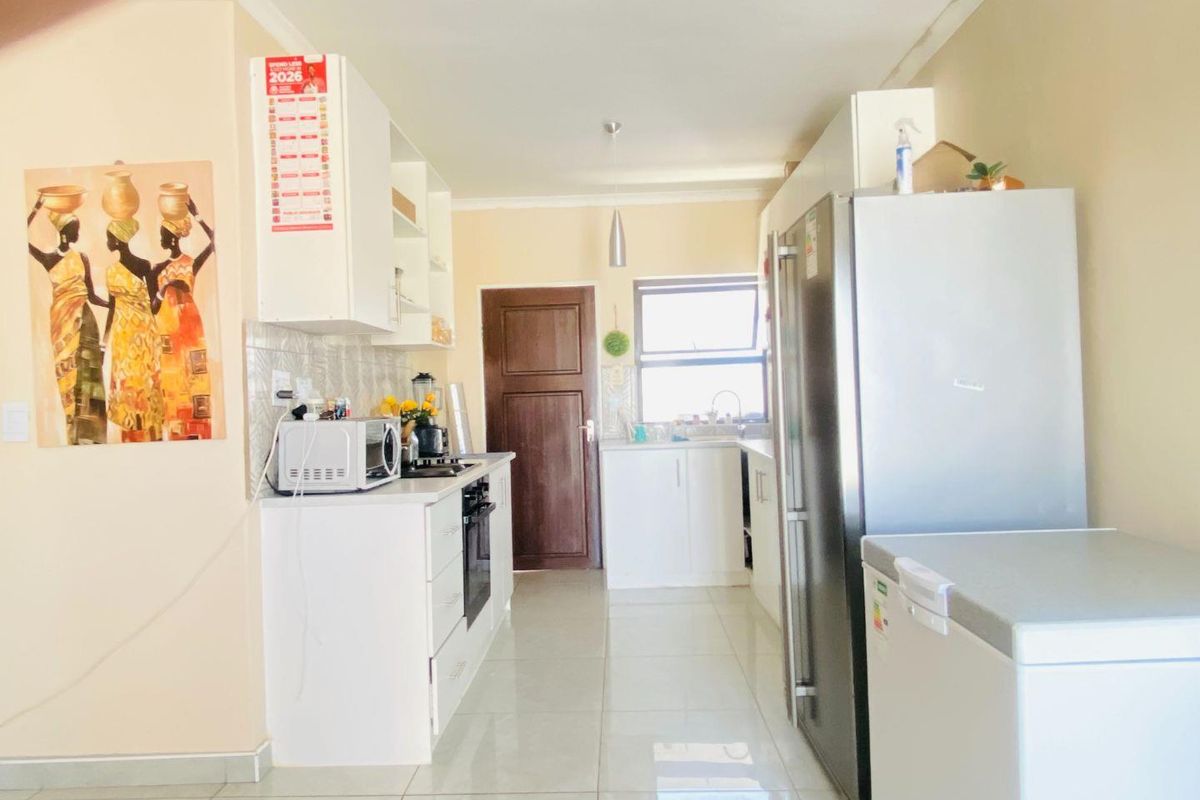 A functional kitchen featuring white built-in cabinetry, tiled flooring, a built-in oven, and a tiled backsplash, providing a clean and practical workspace.