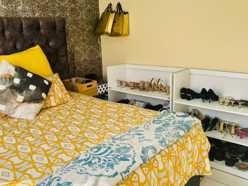 A bedroom featuring tiled flooring and a decorative feature wallpaper wall, providing a functional sleeping space.