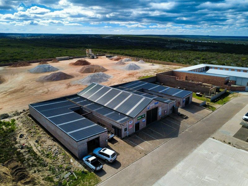Aerial view of a commercial industrial property featuring multiple workshop units, paved parking, and a large rear yard area.