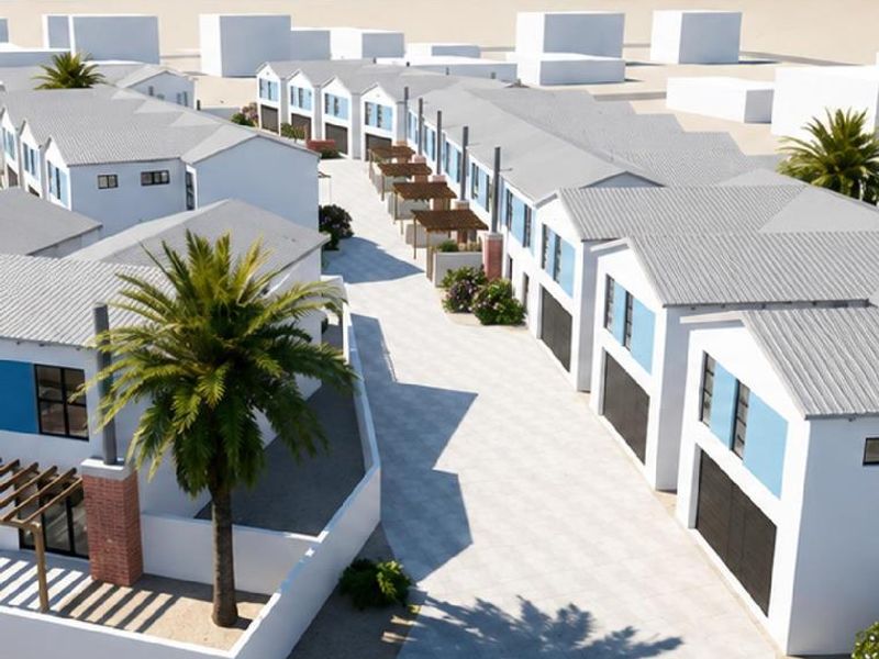 Aerial view of a modern townhouse development featuring uniform pitched roofs, paved driveways, and integrated garage access near the coastline.