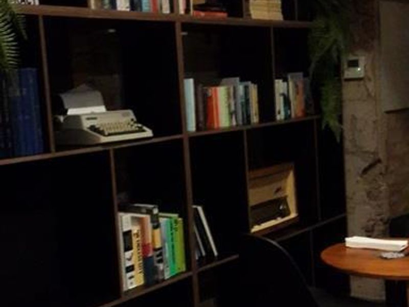 A living area featuring a large, dark built-in shelving unit covering the wall.