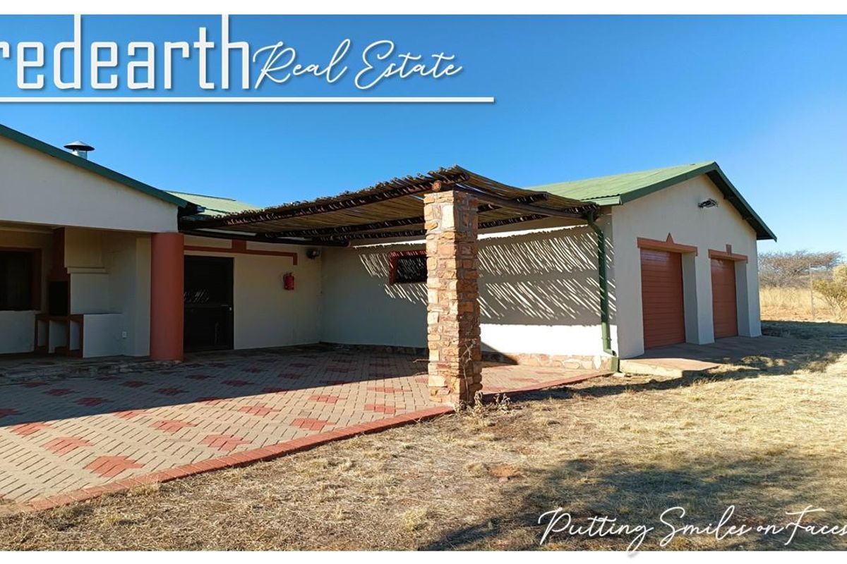 Rear exterior view featuring a paved patio with a stone-clad pillar, timber pergola, built-in braai, and double garage access.
