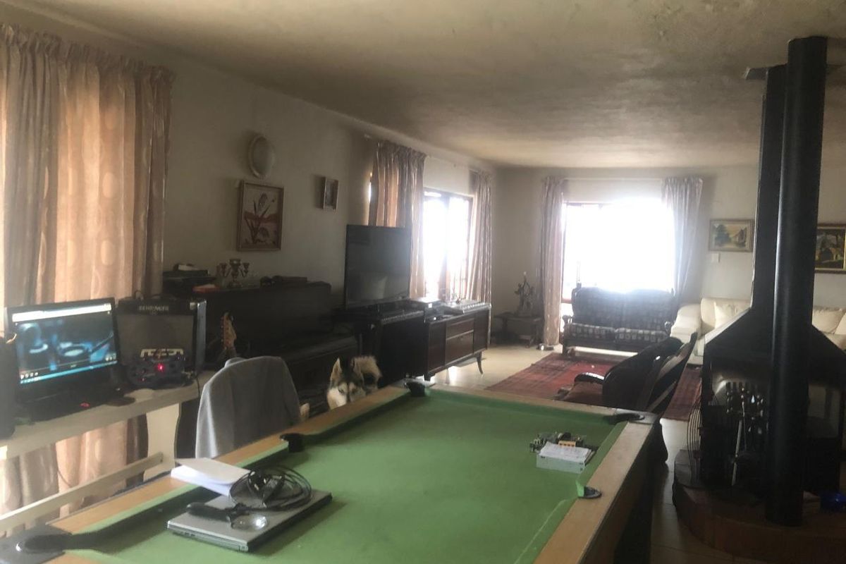 Spacious living area featuring a prominent freestanding fireplace and large windows, offering a versatile layout for relaxation and entertainment.