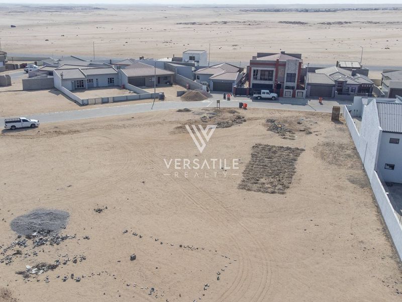 Aerial view of a vacant residential plot in a developed neighborhood, showcasing the surrounding landscape and existing residential infrastructure.