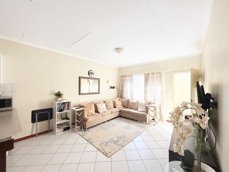 Open plan living area featuring tiled flooring and direct access to the exterior through a security gate.