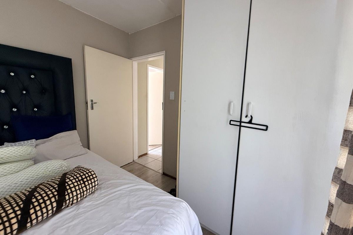 A bedroom featuring built-in white cabinetry and neutral wall finishes, providing a functional and clean living space.