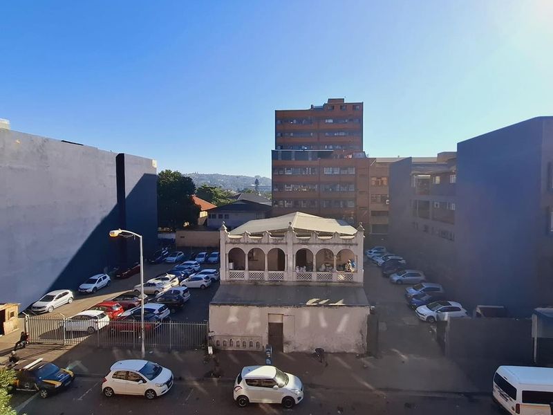 An elevated urban view overlooking a parking area and surrounding apartment buildings in a city setting.