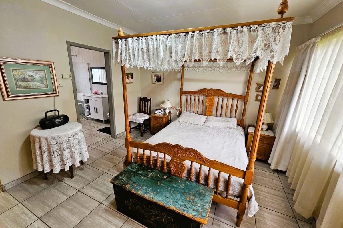 A bedroom featuring tiled flooring and an en-suite bathroom, providing a functional and comfortable living space.