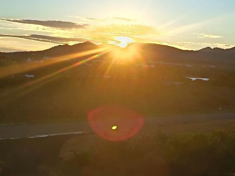 A scenic landscape view featuring a sunset over distant mountains, showcasing the natural beauty and horizon of the vacant residential land.