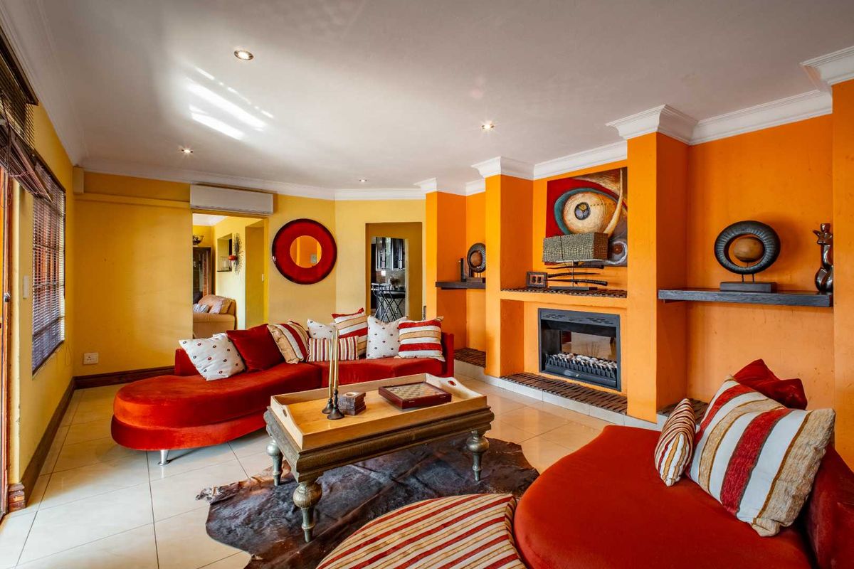 Spacious living room featuring a built-in fireplace, tiled flooring, recessed downlighting, and crown molding, offering a warm and inviting atmosphere.