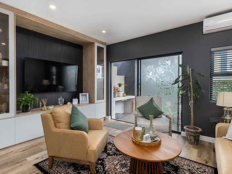Modern living room featuring custom built-in cabinetry, laminate flooring, recessed lighting, and a split-system air conditioner, with direct access to an outdoor patio area.