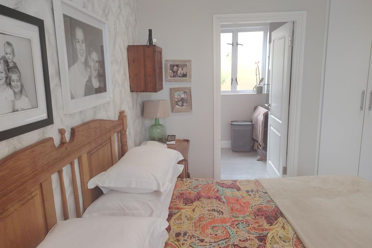 A bedroom featuring built-in wardrobes and a doorway leading to an adjacent space with a window.