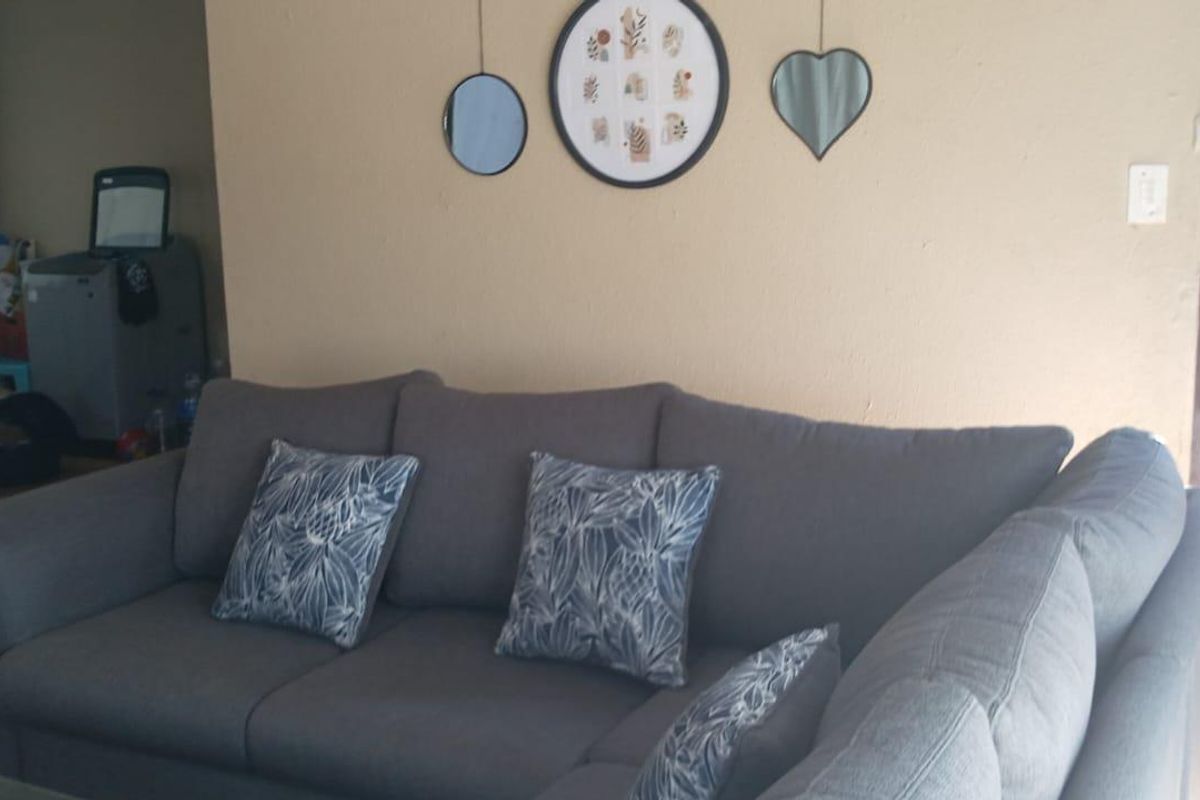 A living room area featuring tiled flooring and direct access to an outdoor patio space.