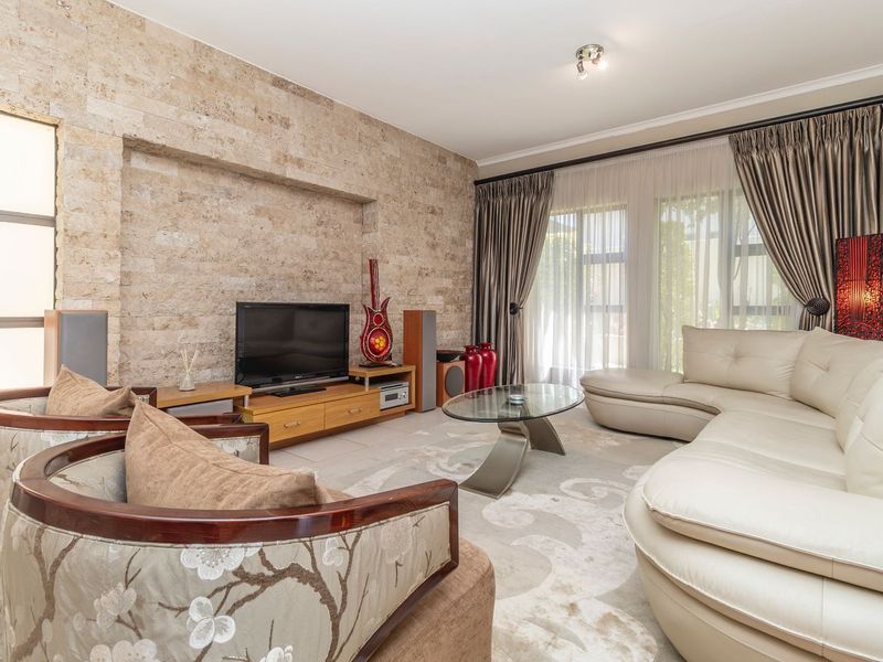A comfortable living room featuring a textured stone accent wall with a built-in niche and large sliding glass doors that provide ample natural light.