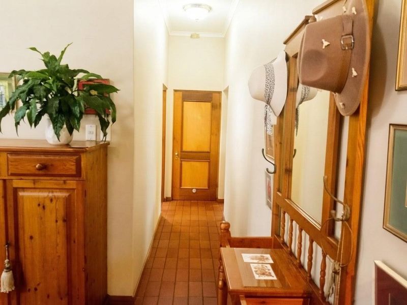 A functional hallway featuring tiled flooring and a classic timber door, providing access to other areas of the home.