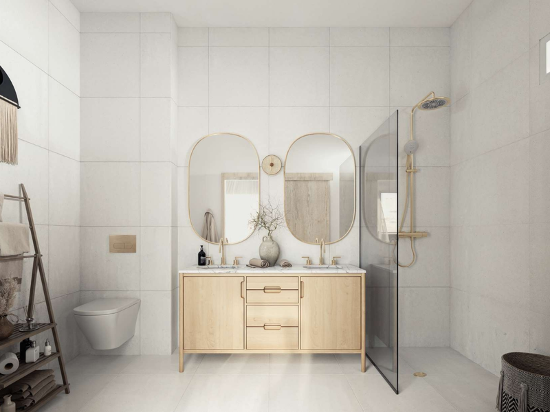 Modern bathroom featuring a double vanity with gold fixtures, wall-mounted toilet, and a walk-in shower with a glass partition and large-format wall tiles.