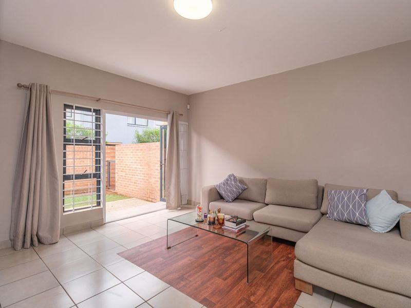 A bright living room featuring tiled flooring and a sliding glass door that provides direct access to the outdoor patio area.