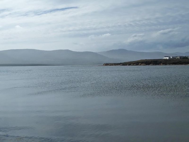 A scenic view of the tranquil lagoon and distant mountains, showcasing the natural beauty and peaceful surroundings of the vacant land.