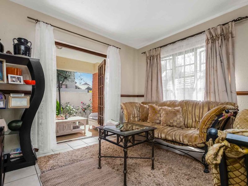 A cozy living room featuring tiled flooring and a classic french door providing direct access to an outdoor patio area.