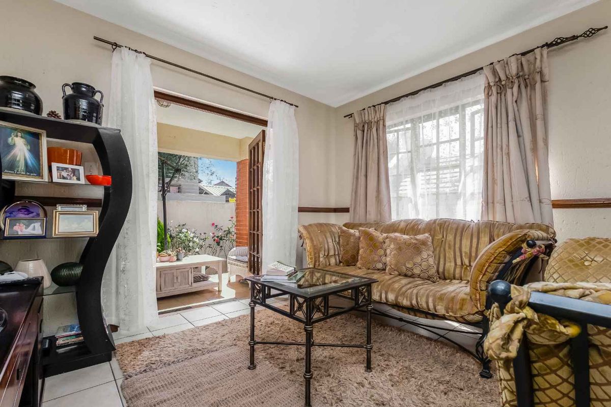 A cozy living room featuring tiled flooring and a classic french door providing direct access to an outdoor patio area.