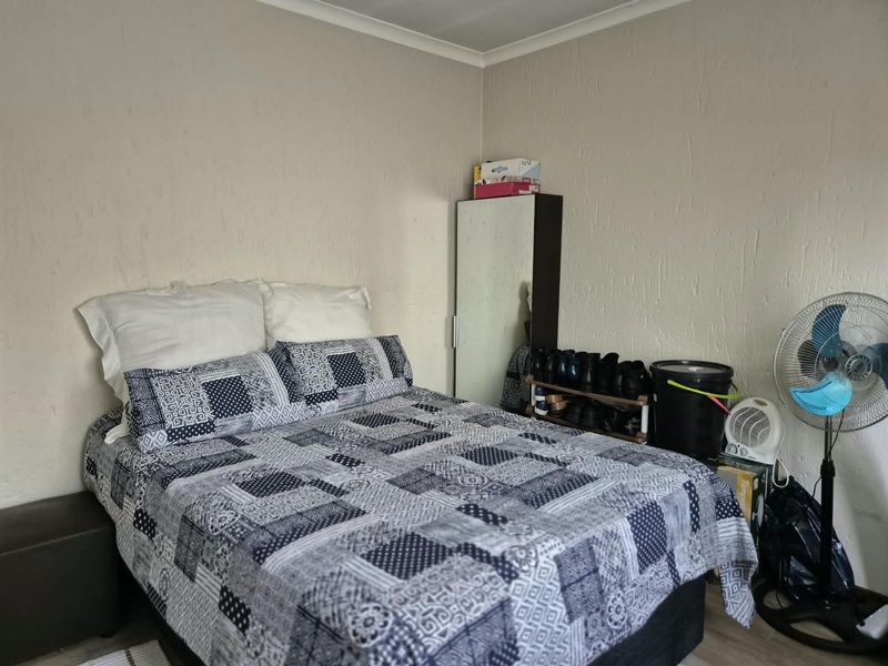 A standard bedroom featuring textured wall finishes and cove cornicing, providing a functional space for rest.