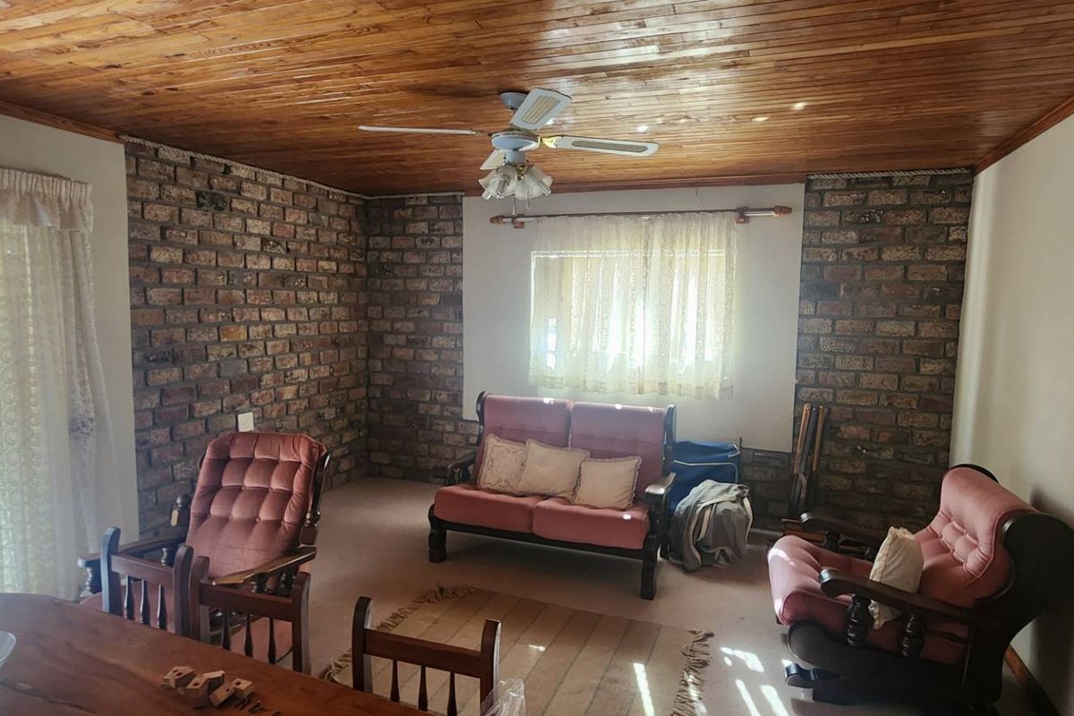A living room featuring exposed brick walls and a timber tongue and groove ceiling, providing a rustic aesthetic with natural light.