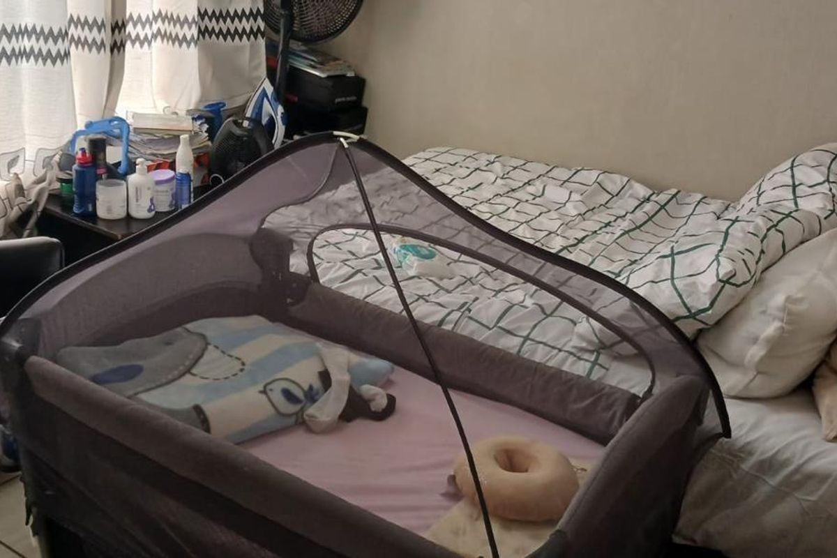 A bedroom featuring tiled flooring and a window with curtains, providing a functional living space.