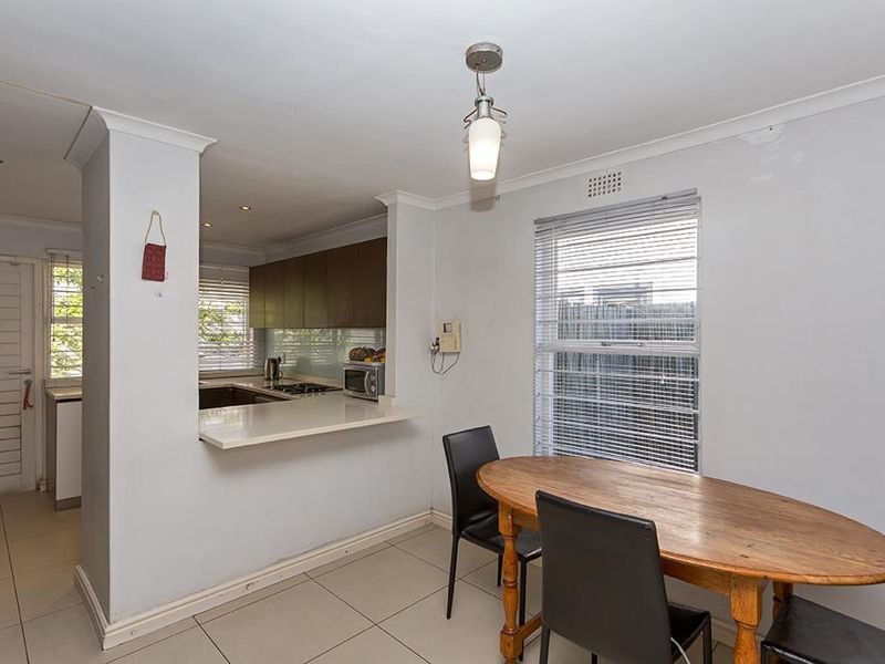 Open plan kitchen and dining area featuring tiled flooring, modern cabinetry, and a breakfast bar, providing a functional space for daily living.
